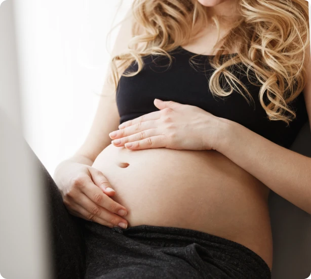 Gestante com as mãos sobre a barriga em um gesto de carinho